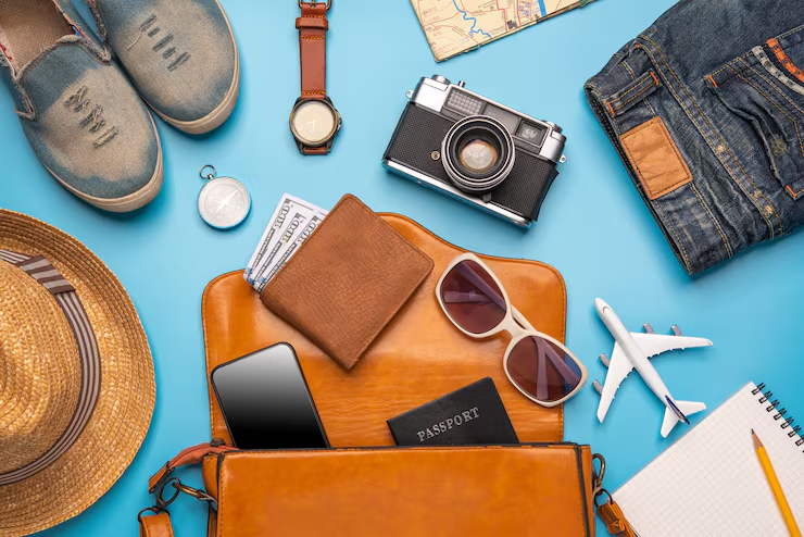 Suitcase, backpack, neck pillow and power bank on a travel route